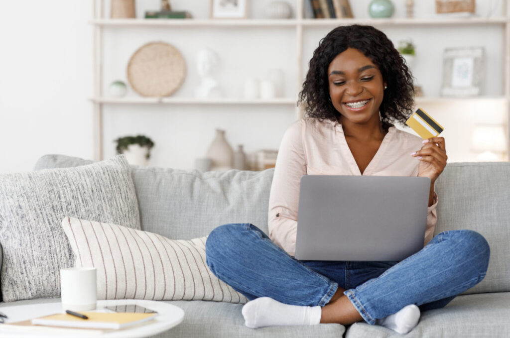 girl on couch online shopping on laptop computer 