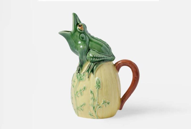 An image of a pitcher that has a frog on it, to which it's mouth is opened to let out fluids.